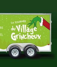 Remorque verte illustrée avec la mention « La tournée du Village Grincheux » et le slogan « Qu’on adore ou qu’on déteste Noël », accompagnée d’une main verte stylisée inspirée du Grinch. Le logo MACH apparaît au bas du visuel.